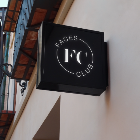 Schild mit dem Schriftzug "Faces Club" auf schwarzem Hintergrund.